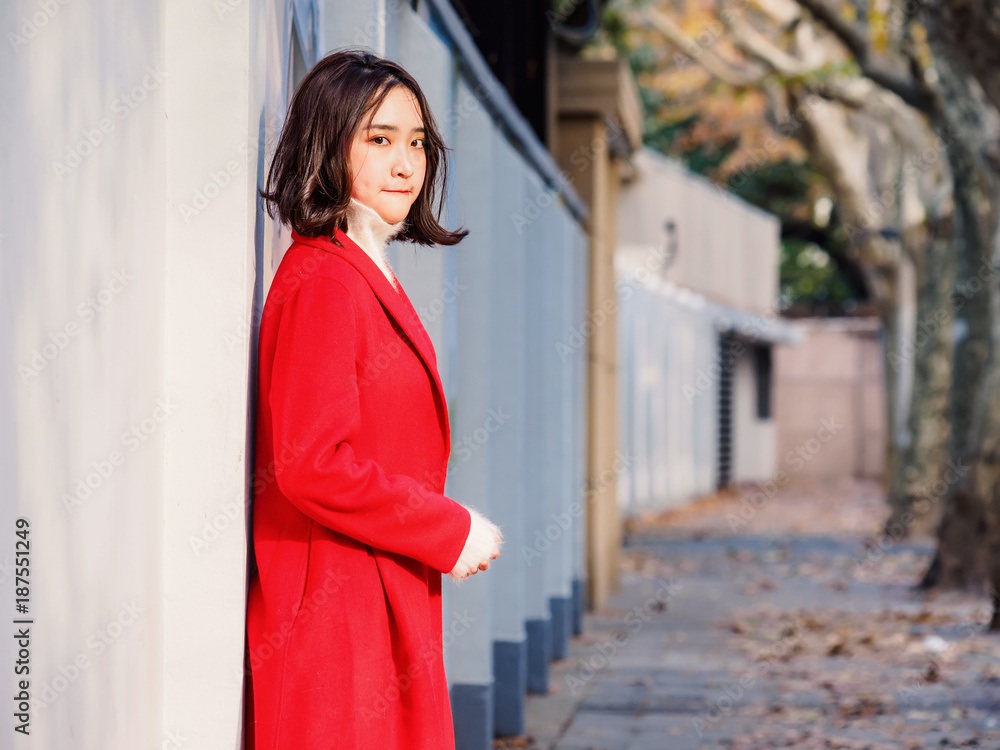 Beautiful young brunette woman wearing a red coat in autumn city. Outdoor fashion portrait of glamour young Chinese cheerful stylish lady in street. Emotions, people, beauty and lifestyle concept. Beautiful young brunette woman wearing a red coat in autumn city. Outdoor fashion portrait of glamour young Chinese cheerful stylish lady in street. Emotions, people, beauty and lifestyle concept.