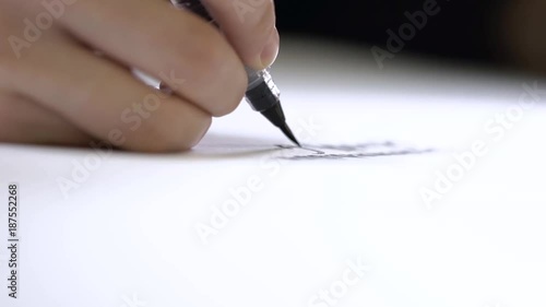 Hand writing calligraphically with a brush on paper.