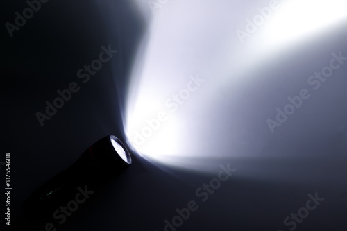 Beam of a flashlight on a white background, light and shadow concepts. photo