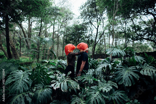 couple with orange fish masks on a rainforest photo