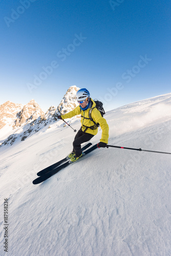 Man skiing downhill steep slope with high speed photo