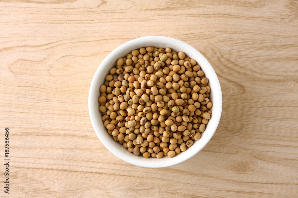 Soybeans in a white bowl on a wooden floor. Soybeans in a white bowl on a wooden floor.