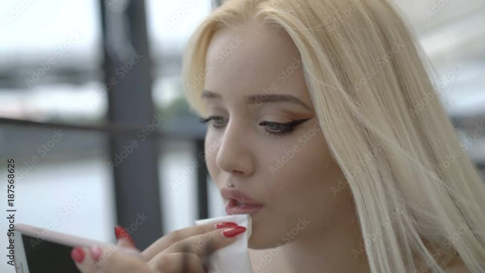 Pretty girl wipes off the lipstick from her lips
Pretty girl wipes off the lipstick from her lips