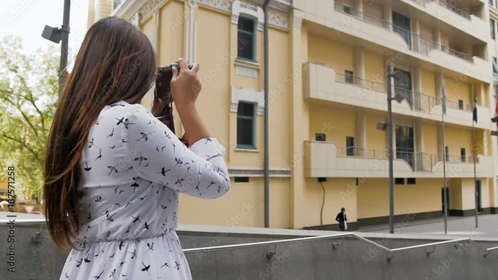 Slow motion video of stylish young woman making photographs with old camera Slow motion video of stylish young woman making photographs with old camera
