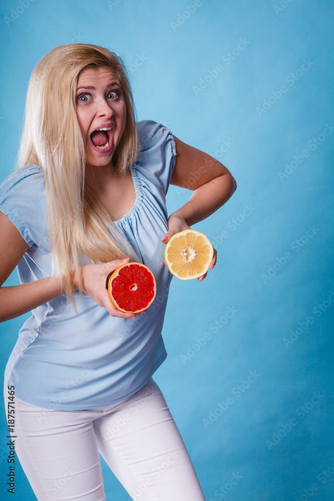 Woman holding red and green grapefruit Woman holding red and green grapefruit