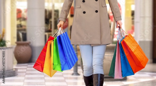 Women walking in a mall with handfull of shopping bags