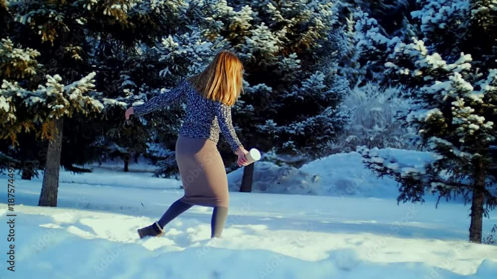 Happy young woman playing with snow