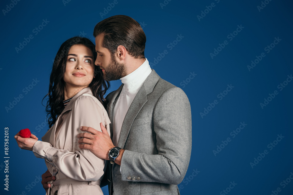 boyfriend making proposal to girlfriend and they looking at each other isolated on blue