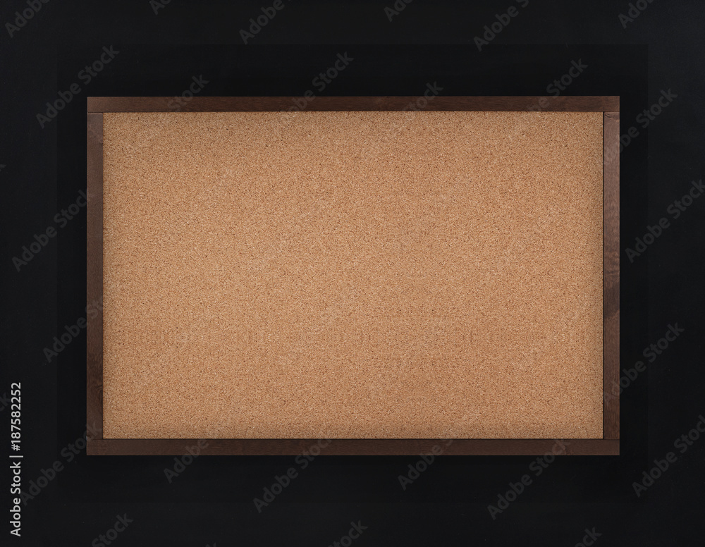 Fototapeta premium Empty corkboard (cork board) in frame on black wall