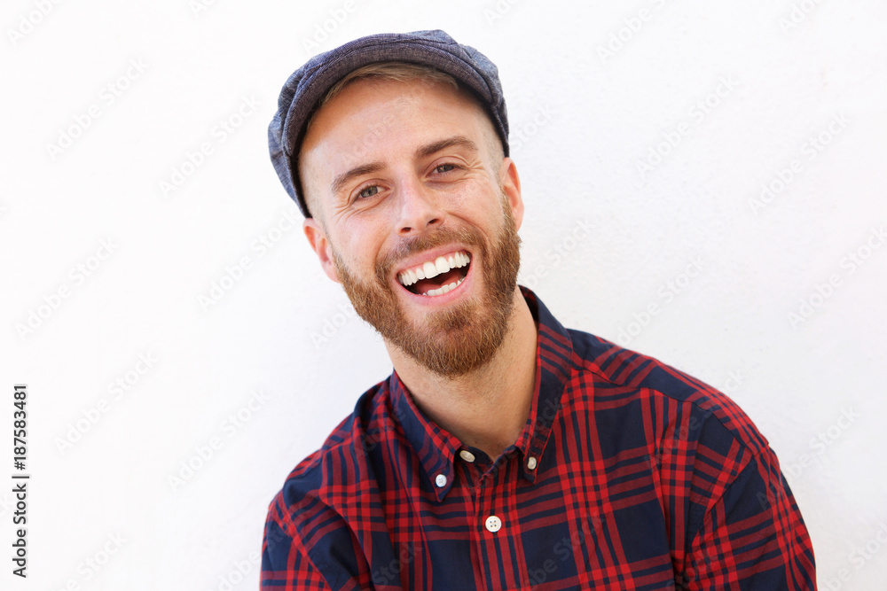 Close up young man laughing with hat against white background Close up young man laughing with hat against white background