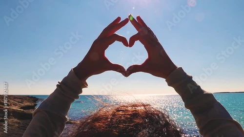 heart shaped by hands , beautiful sea background 