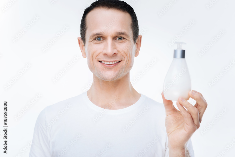 Absolutely clean. Cheerful nice happy man holding soap and showing you it while being in a good mood Absolutely clean. Cheerful nice happy man holding soap and showing you it while being in a good mood