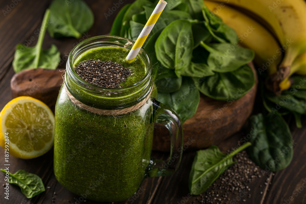 Healthy breakfast with green smoothie in glass jar and ingredients. Detox, diet, healthy, vegetarian food concept. Dark photo, high angle view.