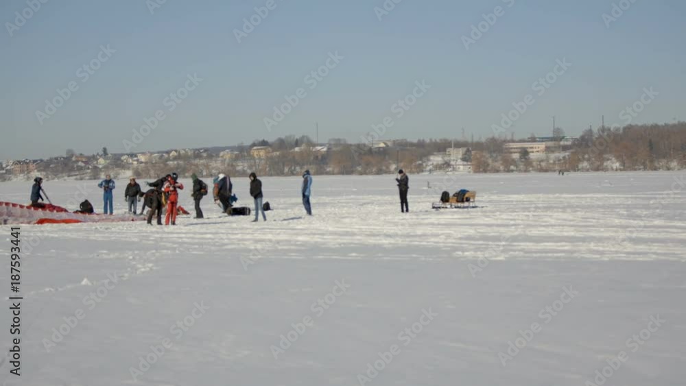 competition paragliders on the frozen lake. Paragliding landingpreparation for paragliding competition. winter paragliding competition on a frozen lake near the city park. Ternopil Ukraine competition paragliders on the frozen lake. Paragliding landingpreparation for paragliding competition. winter paragliding competition on a frozen lake near the city park. Ternopil Ukraine