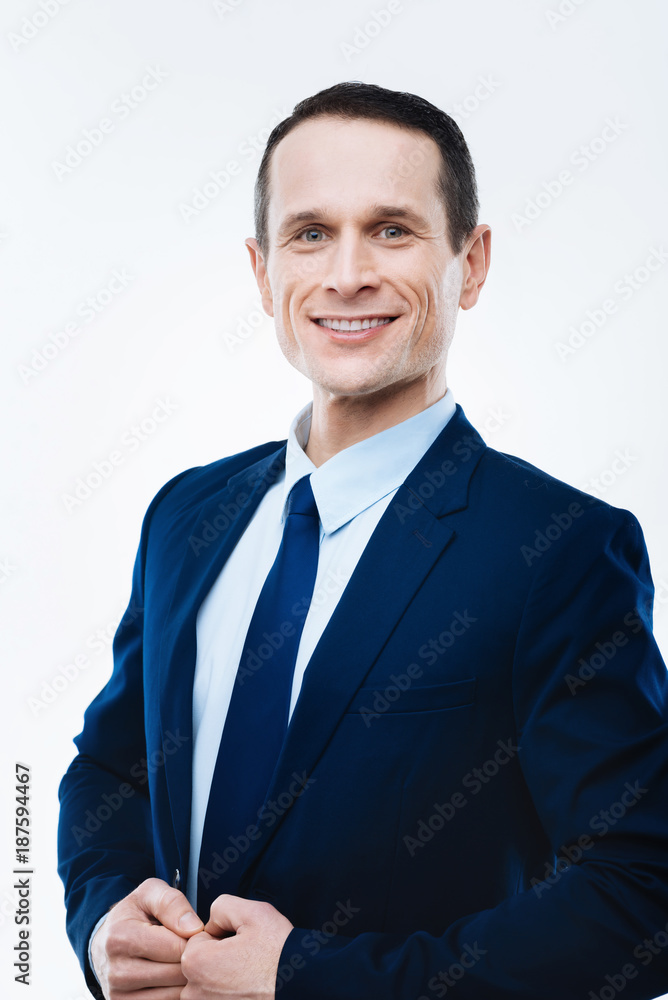 Successful businessman. Cheerful smart nice man looking at you and smiling while being a successful businessman Successful businessman. Cheerful smart nice man looking at you and smiling while being a successful businessman