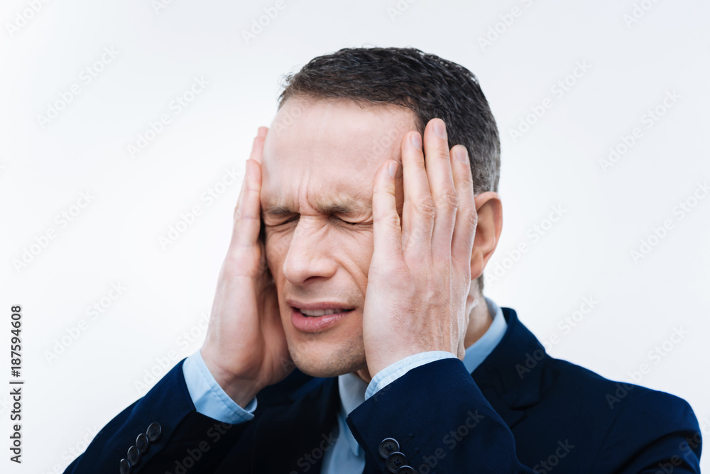 Too many problems. Unhappy serious adult man closing his eyes and holding the head while thinking about his problems Too many problems. Unhappy serious adult man closing his eyes and holding the head while thinking about his problems