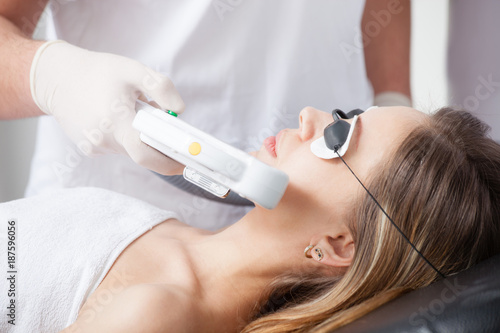 woman during face laser therapy in cosmetics
