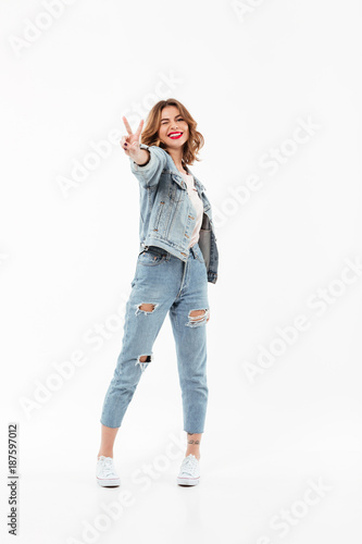Full length image of Pleased woman in denim clothes winks