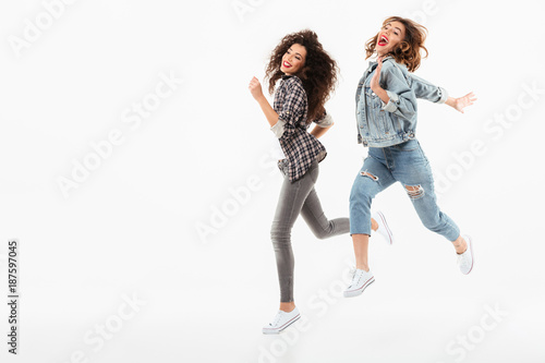 Full length image of two girls running together in studio