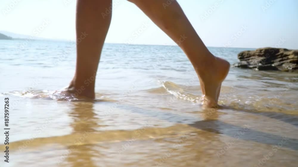 Female legs close up. Woman feet and legs walking on beach.Ocean surf. Tropical island. Slow mothion.. Female legs close up. Woman feet and legs walking on beach.Ocean surf. Tropical island. Slow mothion..
