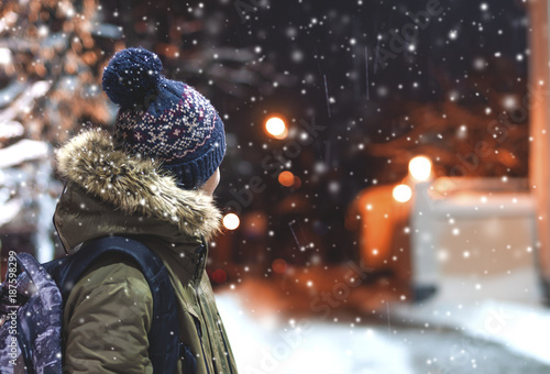 happy young man on a city street during a snowfall