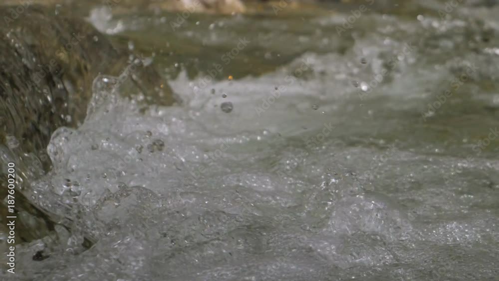 Beautiful water in a mountain river in slow motion video. Shooting speed 180fps, slow motion. Live shooting of the most beautiful nature river mountain water. The camera is static. Beautiful water in a mountain river in slow motion video. Shooting speed 180fps, slow motion. Live shooting of the most beautiful nature river mountain water. The camera is static.