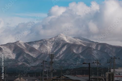 A snowy mountain view at Akita with blue cloudy sky.