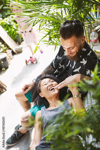 Multi ethnic couple reclining on garden bench in residential alleyway, Shanghai French Concession, Shanghai, China photo