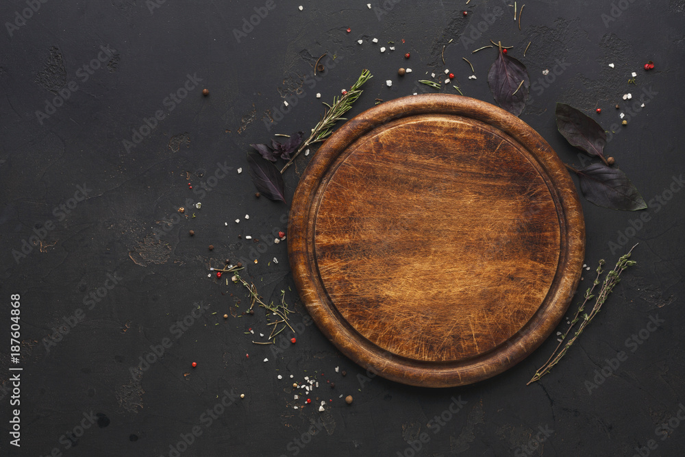 Round wooden plate on dark wooden background top view Stock Photo