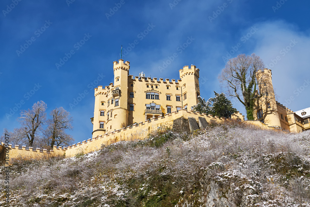 Hohenschwangau Castle (schloss) on the snowy cliff under blue sky, Bavaria, Germany