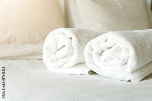 White towels on bed in hotel bedroom closeup