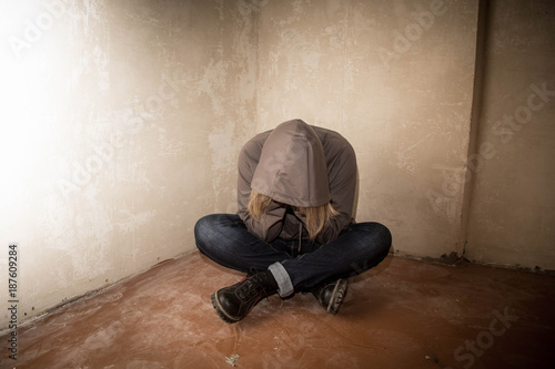 Portrait of man sad, drug addict man sitting on the floor in corner © dashtik