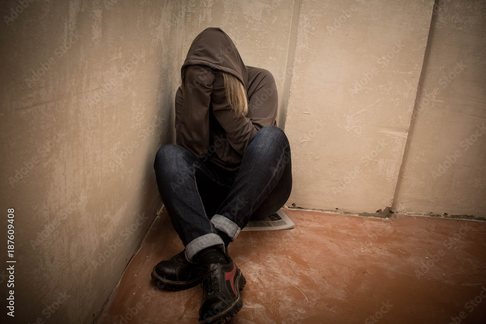 Portrait of man sad, drug addict man sitting on the floor in corner Portrait of man sad, drug addict man sitting on the floor in corner