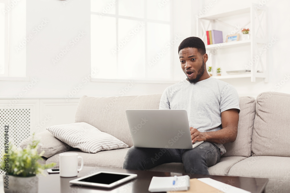 Young man at home messaging online on laptop Young man at home messaging online on laptop