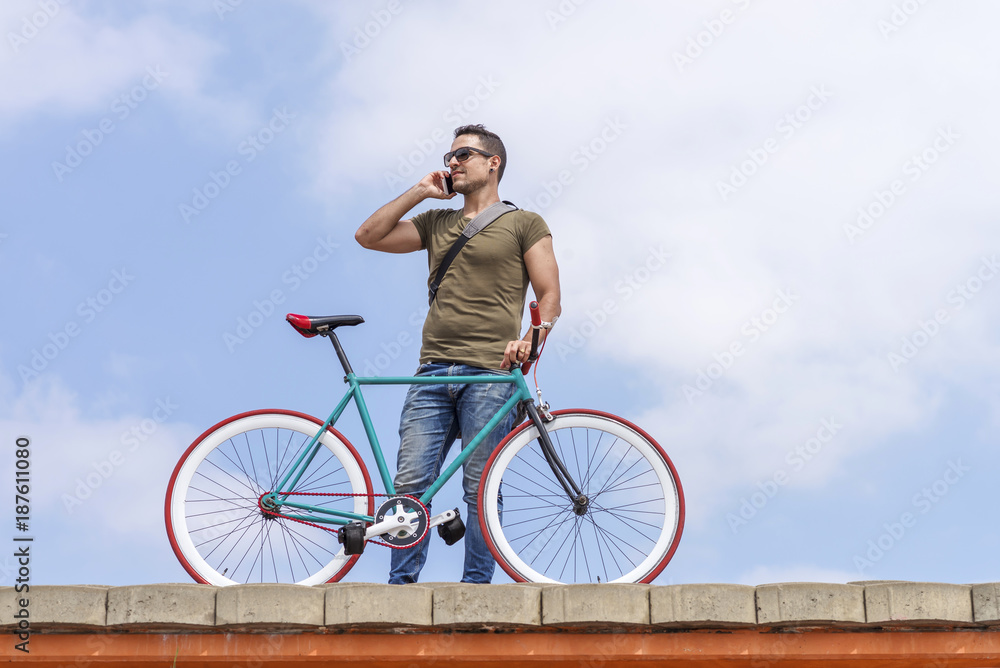 Attractive young  man standing outdoors and calling on the phone