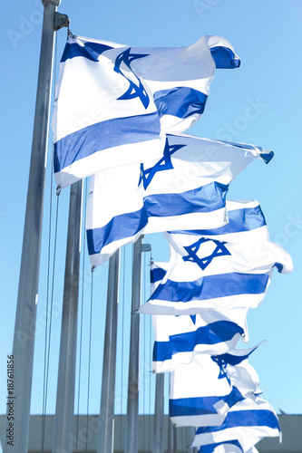 Israeli Flags in the wind with blue sky background near to the Knesset