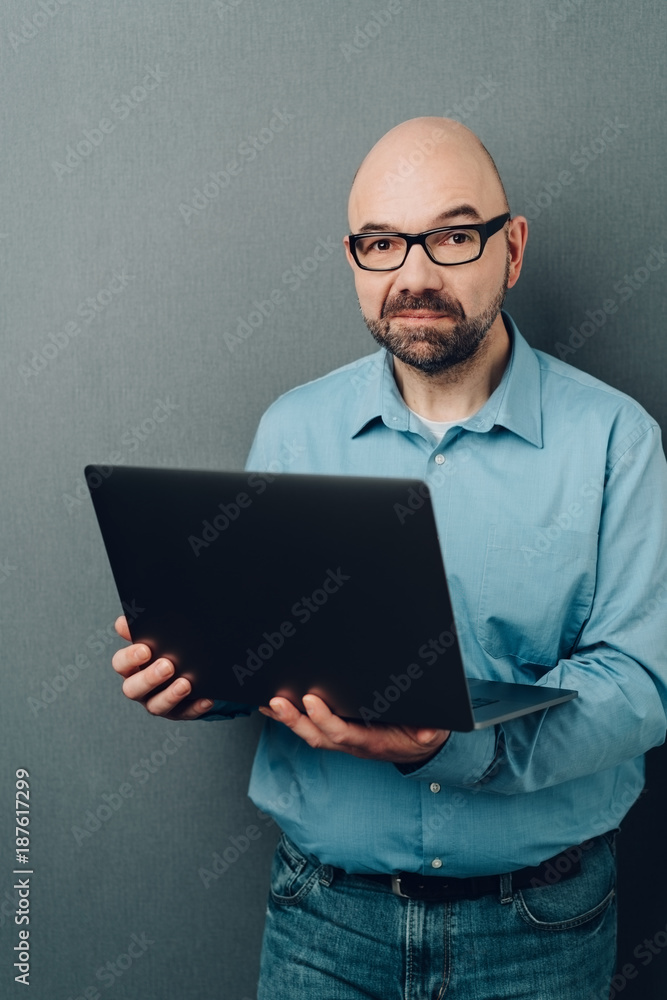 Bald man in glasses with laptop computer Bald man in glasses with laptop computer