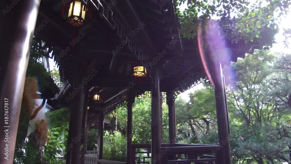 Chinese architecture on display with trees, sunlight and lens flare in this shot from a Chinese Garden. Shot in 4K UHD. Chinese architecture on display with trees, sunlight and lens flare in this shot from a Chinese Garden. Shot in 4K UHD.