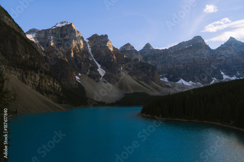 Blue water of Moraine Lake in Rocky Mountains in Canada during  colorful sunset
