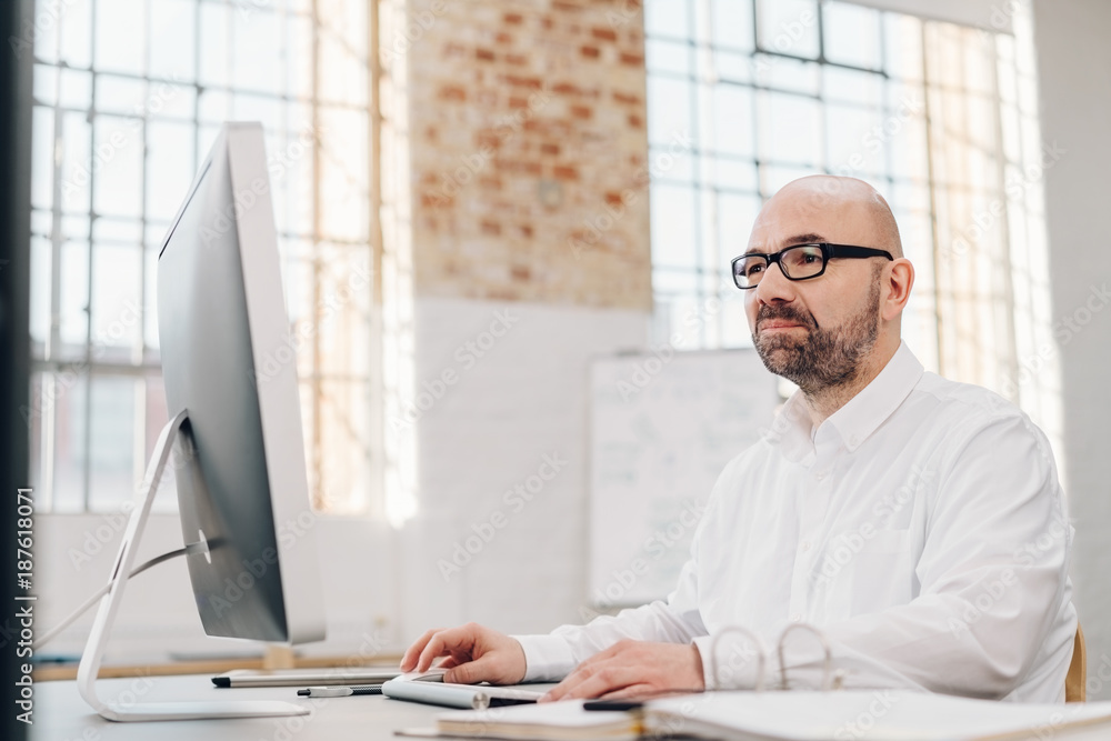 Businessman working on a large desktop monitor Businessman working on a large desktop monitor