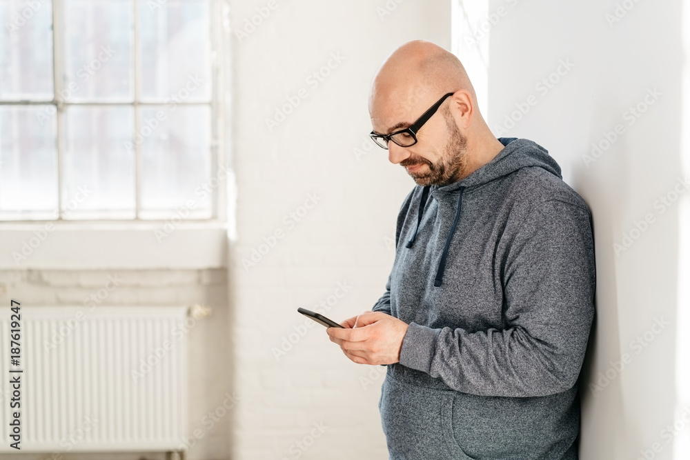 Fototapeta premium Side view of middle-aged man using a mobile phone
