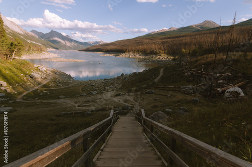 Colorful landscape with lake and forest in Rocky Mountains, Alberta during sunset with clouds