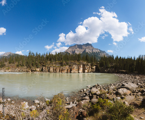 Scenic remote wide valley with river and forest in Rocky Mountains in Canada on sunny day