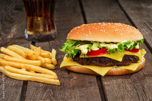 Fast food. Cheeseburger and french fries on a wooden background