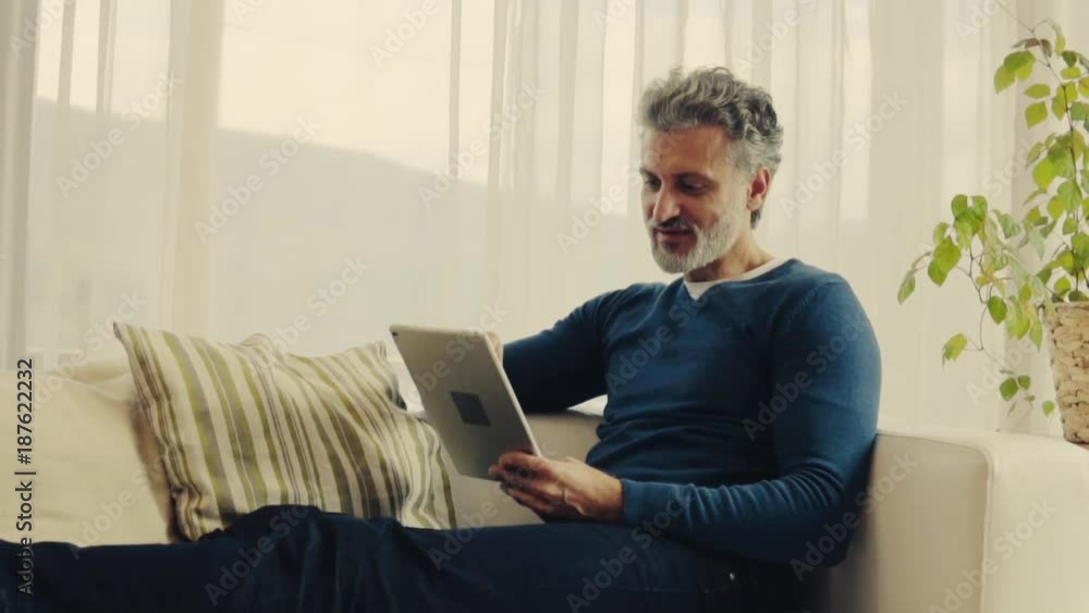 A mature man with tablet at home. A mature man with tablet at home.