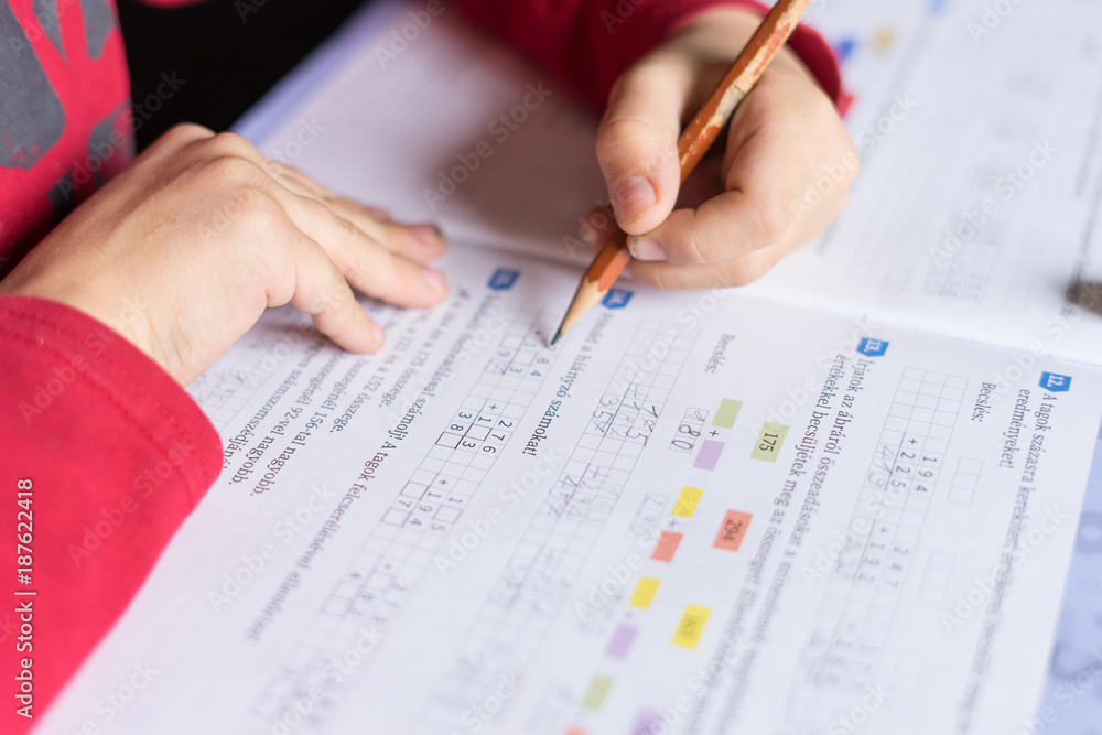 child hand hold pencil and writes to math books child hand hold pencil and writes to math books
