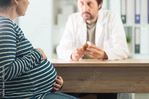 Doctor prescribing pills to pregnant woman