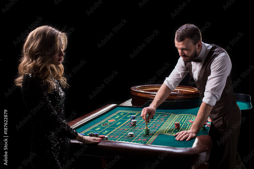 Croupier and woman player at a table in a casino. Picture of a c Croupier and woman player at a table in a casino. Picture of a c