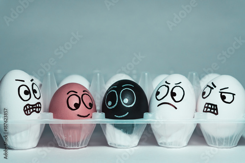 Faces on eggs in the form of facial expressions, reflecting emotions. The concept of racism, misunderstanding, a barrier in relations, denial of society. Barriers between people, prejudice. photo