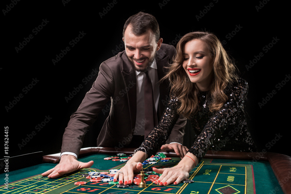 Man and woman playing at roulette table in casino Man and woman playing at roulette table in casino